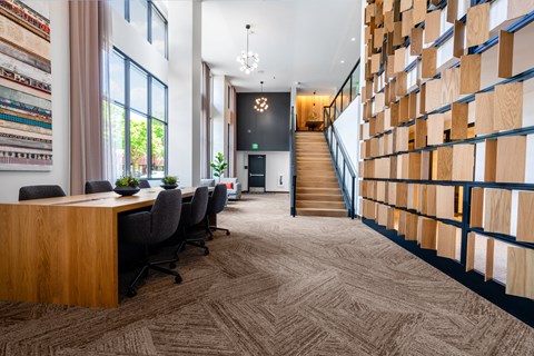 the lobby of a library with a table and chairs and a staircase