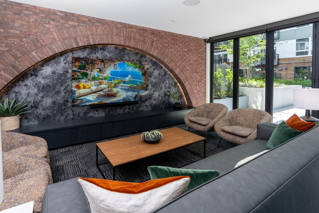 a living room with a couch and chairs and a mural on the wall
