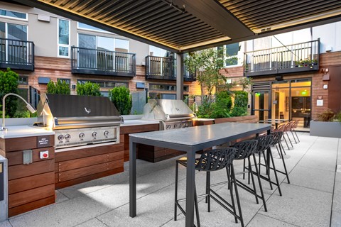 a large outdoor kitchen with a table and chairs