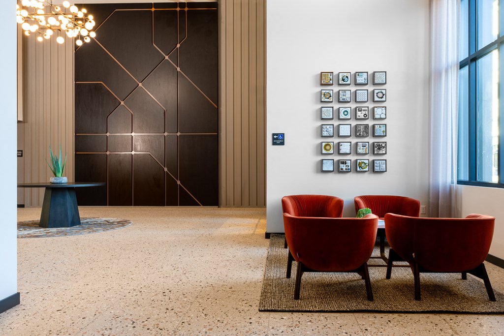 a lobby with red chairs and a picture on the wall