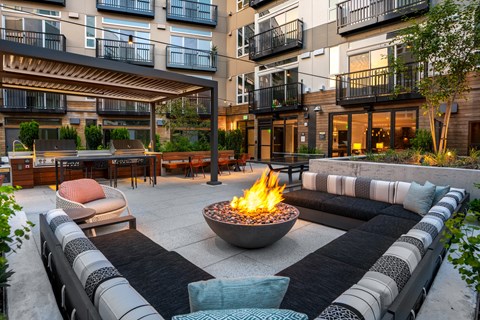 an outdoor patio with couches and a fire pit