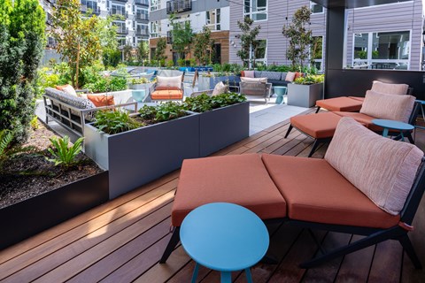 a patio with couches and tables on a roof top