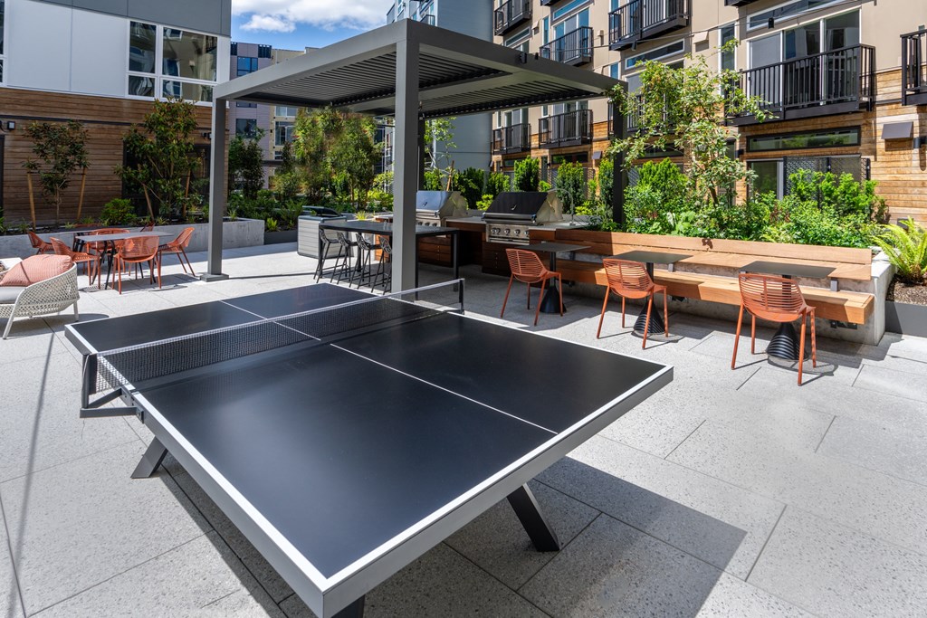 a ping pong table on a patio with tables and chairs