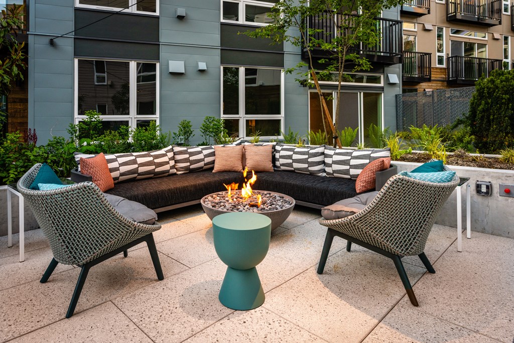 a fire pit on a patio with chairs and a couch