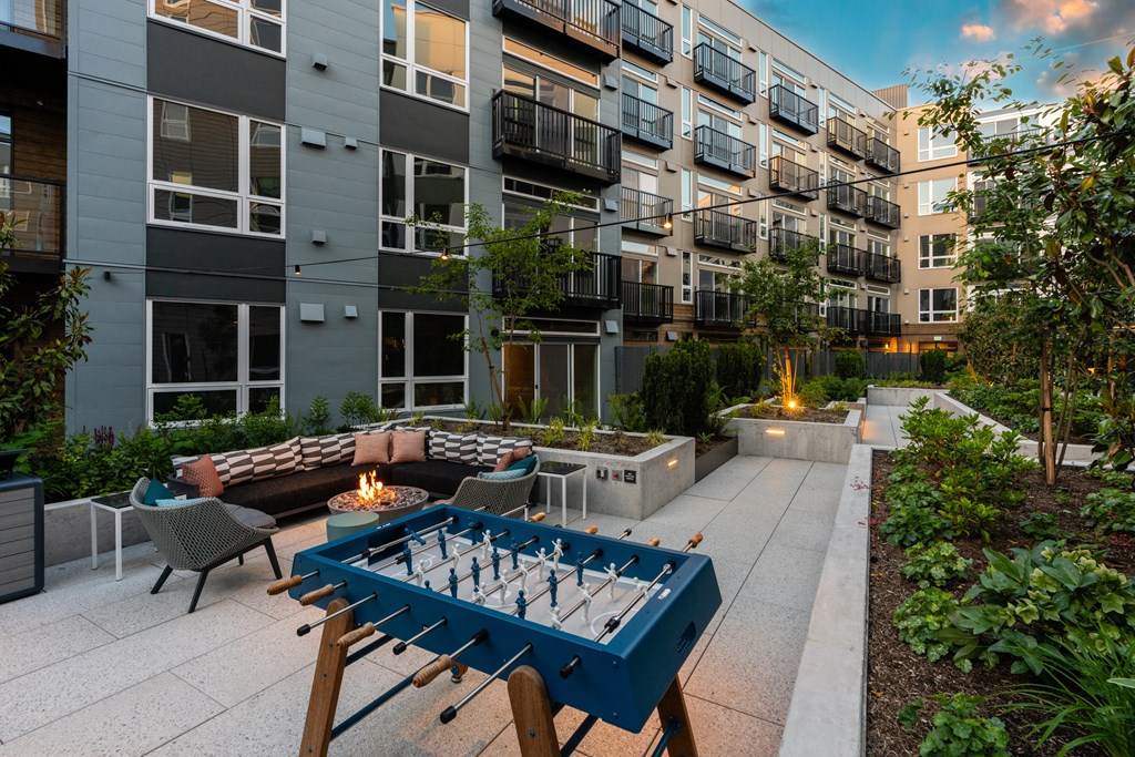 an outdoor patio with a fire pit and a blue ping pong table