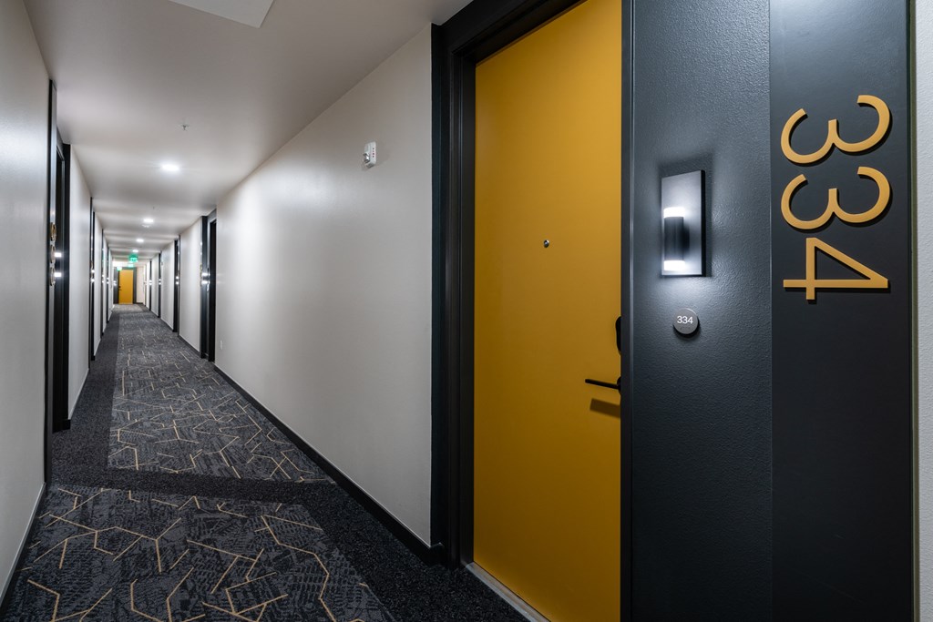 a hallway with black and yellow doors and a yellow door knob