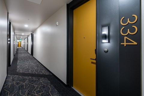 a hallway with black and yellow doors and a yellow door knob