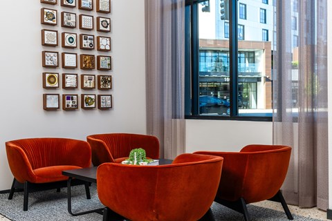 a group of orange chairs in a room with a window