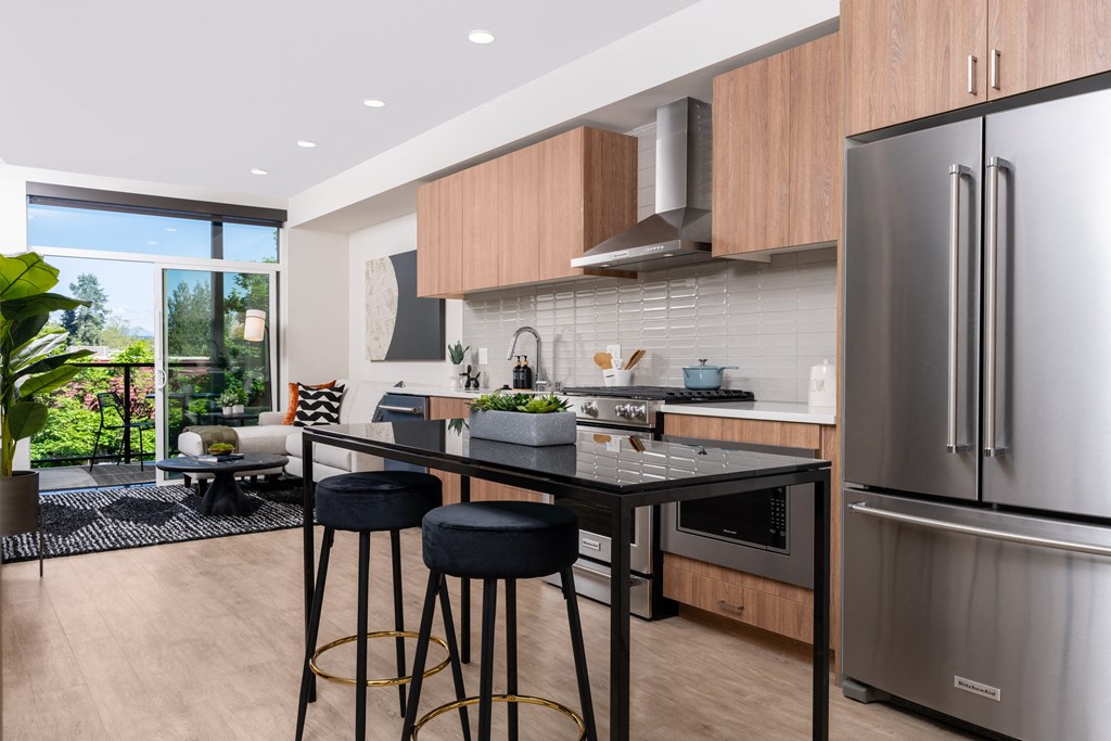 a kitchen with stainless steel appliances and an island with three stools