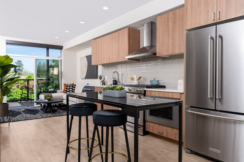 a kitchen with stainless steel appliances and an island with three stools
