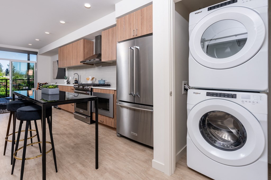 a kitchen with a washing machine and a washer and a dryer in it