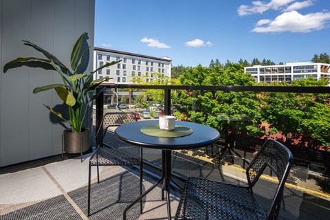 a small patio with a blue table and chairs on a balcony