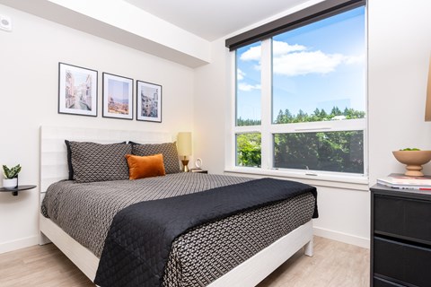 a bedroom with a bed and a large window