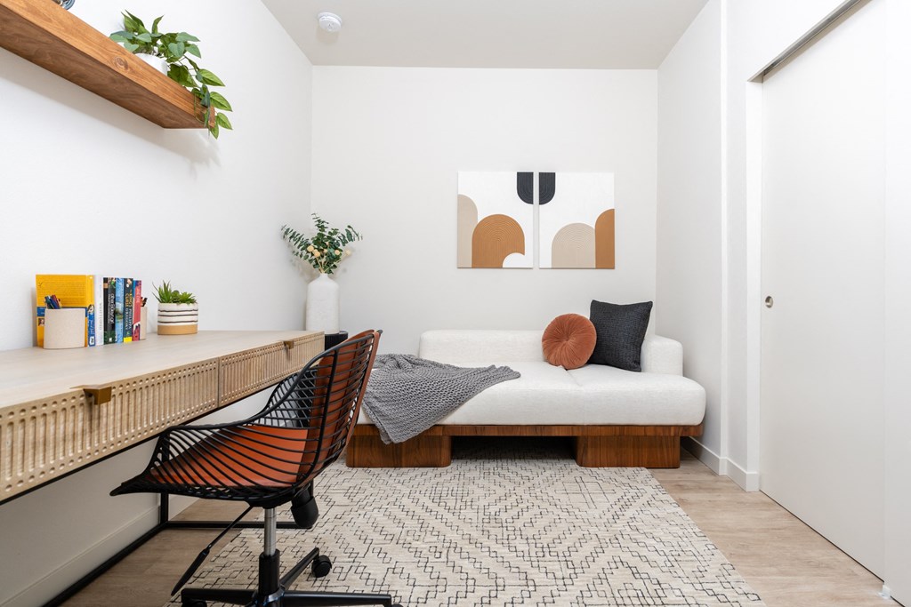 a bedroom with a bed and a desk and a rug