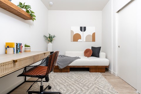 a bedroom with a bed and a desk and a rug