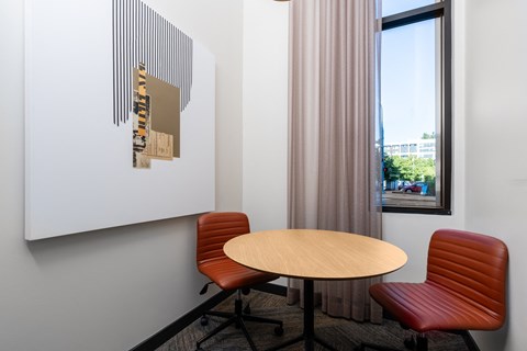 a table and two chairs in a room with a window