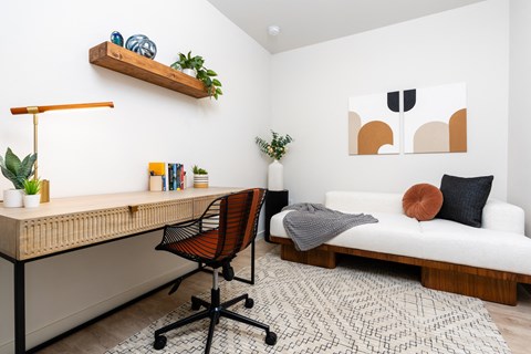 a bedroom with a bed and a desk with a chair