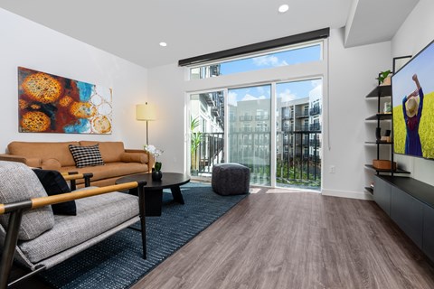 a living room with a couch and a chair and a sliding glass door