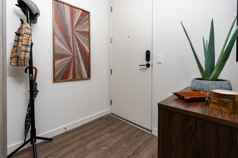 a hallway with a dresser and a painting on the wall and a door to