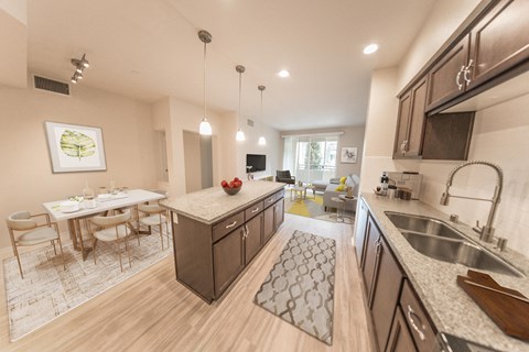 an open kitchen and living room with a dining area and a table