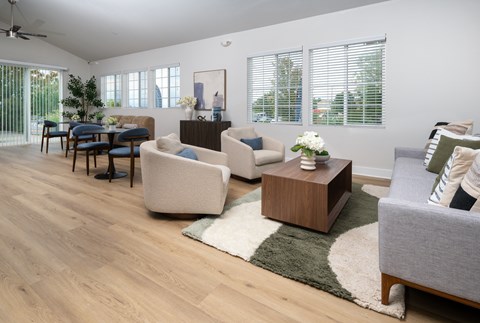 A living room with a white couch, a blue chair, and a wooden coffee table.