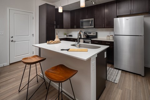 A kitchen with a white countertop and a stainless steel refrigerator.