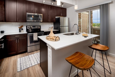 A kitchen with a white countertop and brown cabinets.