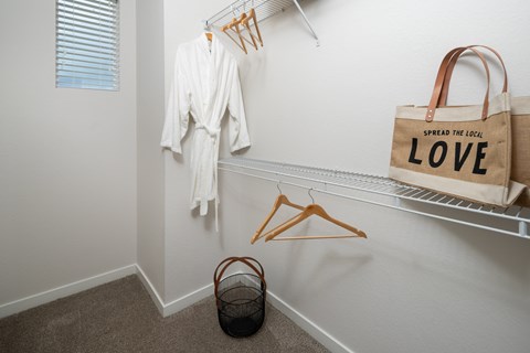 A white robe is hanging on a hanger in a room.