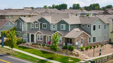 A row of houses with green and grey roofs.