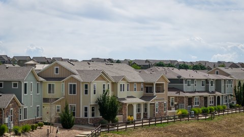 A row of houses with different colored roofs.