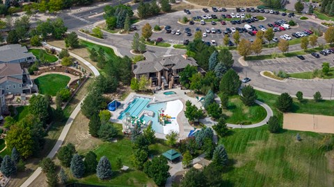 An aerial view of a residential area with a swimming pool and a parking lot.