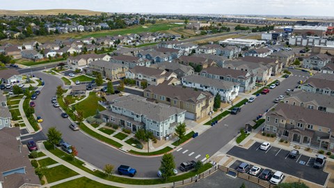 A suburban neighborhood with houses and cars.