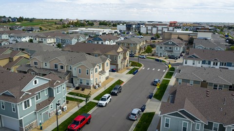 A suburban neighborhood with houses and cars.