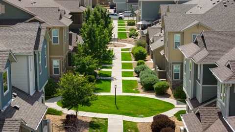 A residential neighborhood with houses and a tree-lined street.