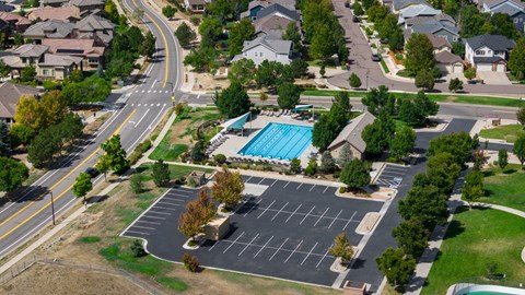 A road with a sidewalk and a parking lot.