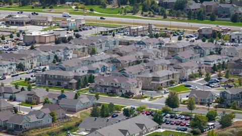 A suburban neighborhood with houses and parked cars.