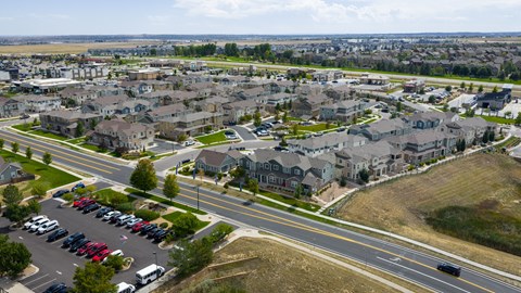 A suburban neighborhood with houses and parked cars.