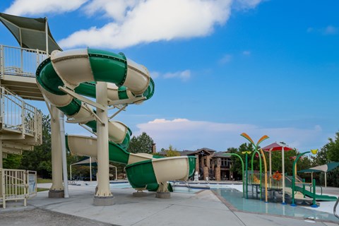 A green and white water slide at a water park.