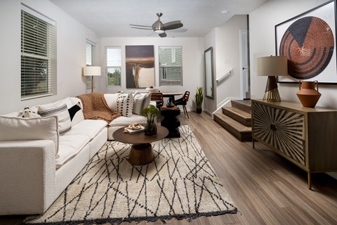 A living room with a white couch, a coffee table, and a rug.