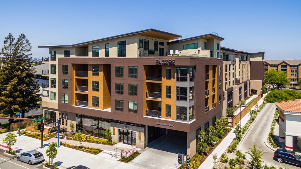 an aerial view of an apartment complex with cars parked in front of it