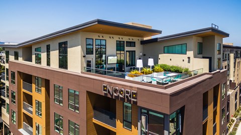 a large apartment building with a rooftop terrace and a pool