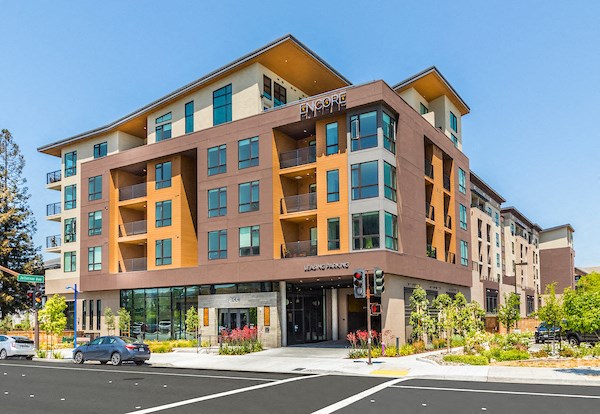 a large apartment building on the corner of a city street