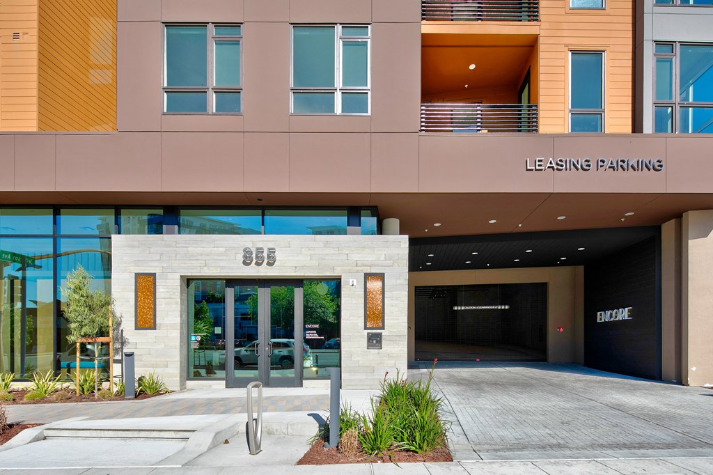 a building with a glass door and a sign that reads leasing parking