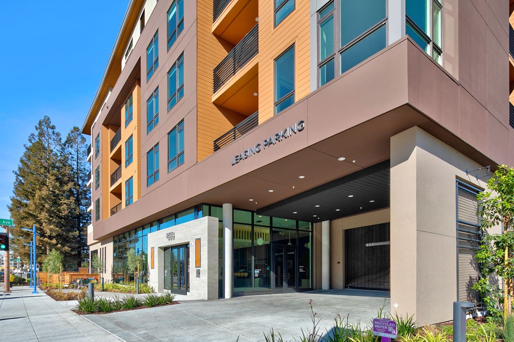 the facade of a hotel with a sidewalk in front of it
