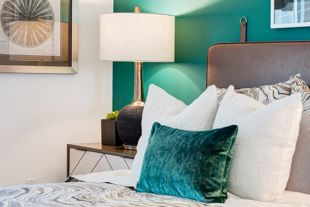 a bedroom with a bed with pillows and a green wall
