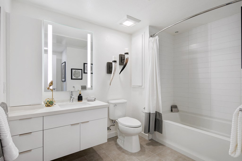a white bathroom with a toilet and a tub and a sink