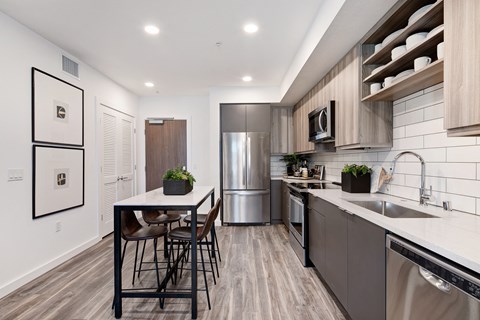 a modern kitchen with stainless steel appliances and a table with chairs