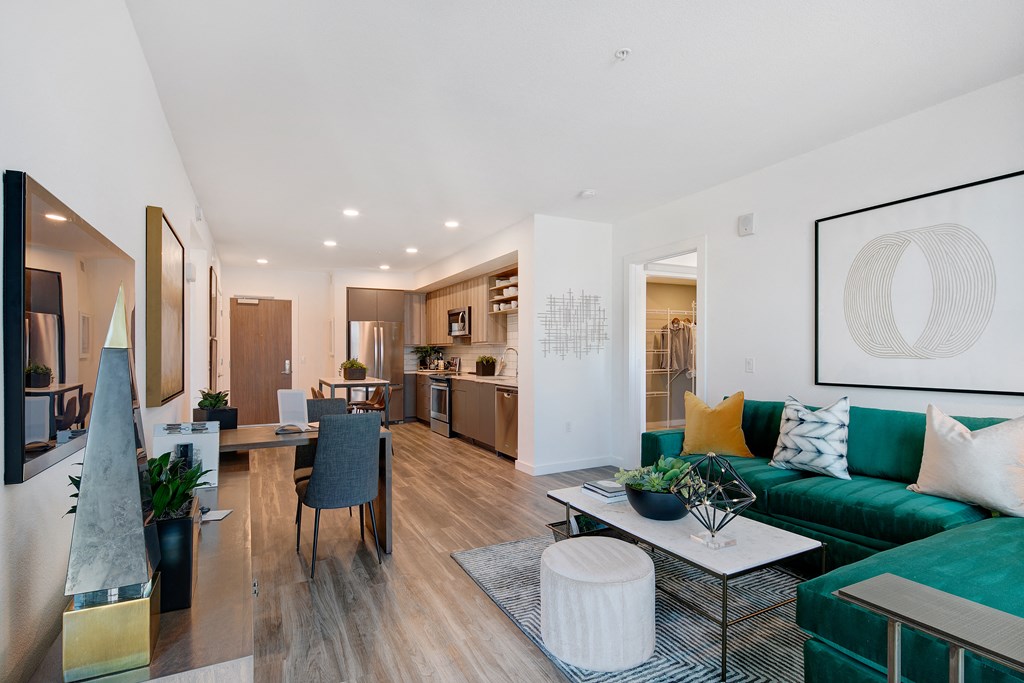 a living room and dining room with a green couch and a table