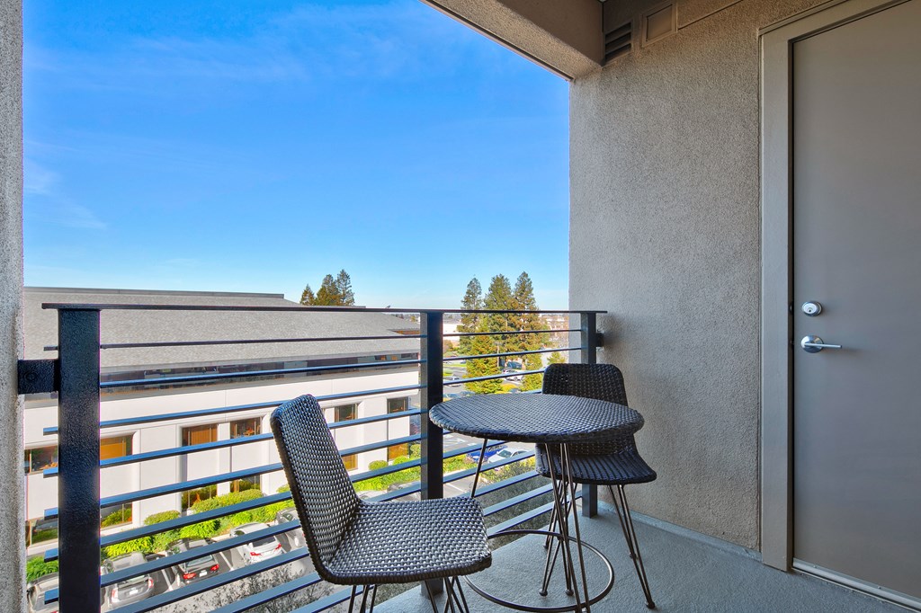 a balcony with two chairs and a table on a balcony