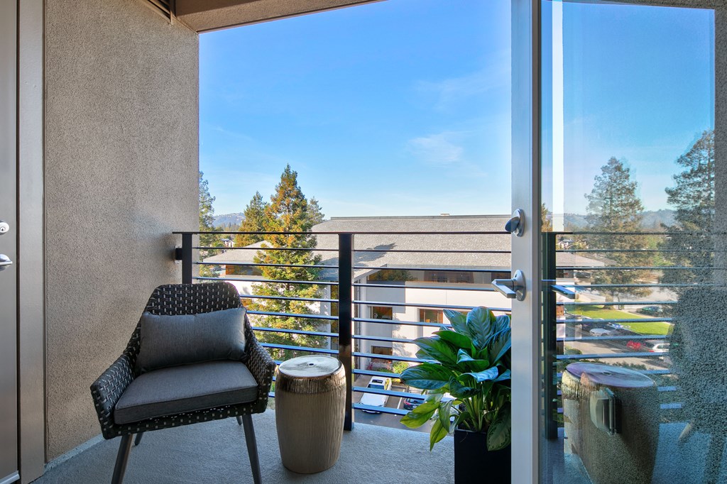 a balcony with a chair and a table and a door